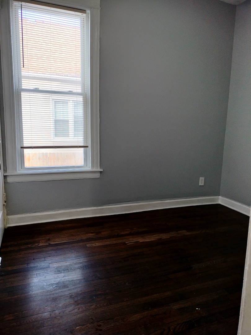 6719 South Sangamon Street, Unit 1 Chicago, IL 60621 - Photo 5 of 23 a view of an empty room with wooden floor and a window