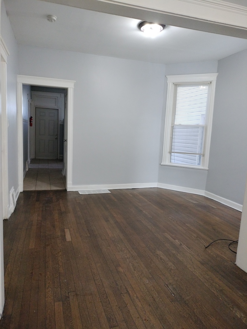 6719 South Sangamon Street, Unit 1 Chicago, IL 60621 - Photo 7 of 23 a view of an empty room with wooden floor and a window
