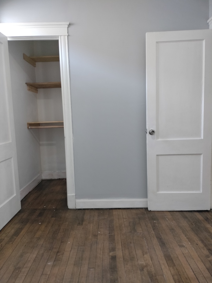 6719 South Sangamon Street, Unit 1 Chicago, IL 60621 - Photo 8 of 23 an empty room with wooden floor and closet