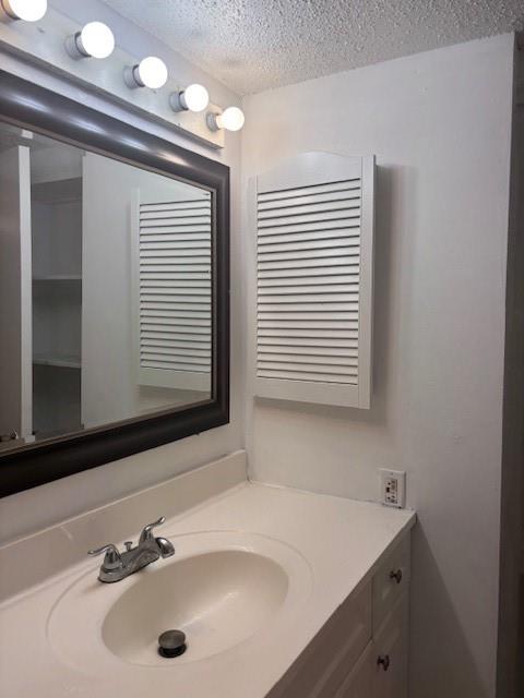 11311 Audelia Road, Unit 208 Dallas, TX 75243 - Photo 6 of 11 Bathroom with a textured ceiling and vanity