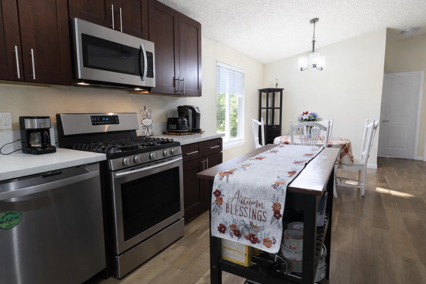 16711 Marsh Creek Road, Unit 74 Clayton, CA 94517 - Photo 6 of 11 a kitchen with stainless steel appliances kitchen island granite countertop a stove a sink and a microwave