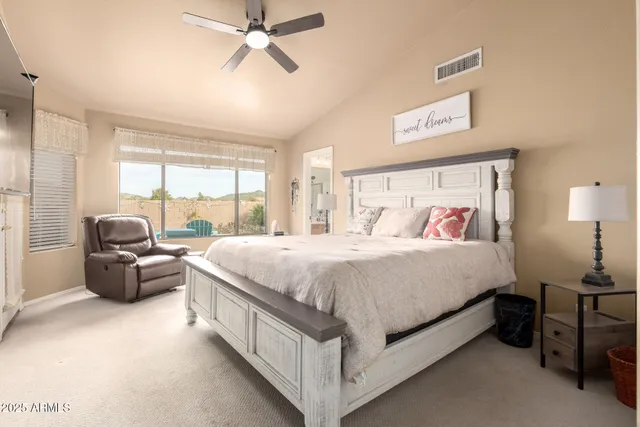 a spacious bedroom with a bed and a large window