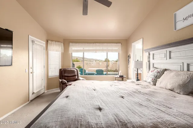 a bedroom with a bed and large windows