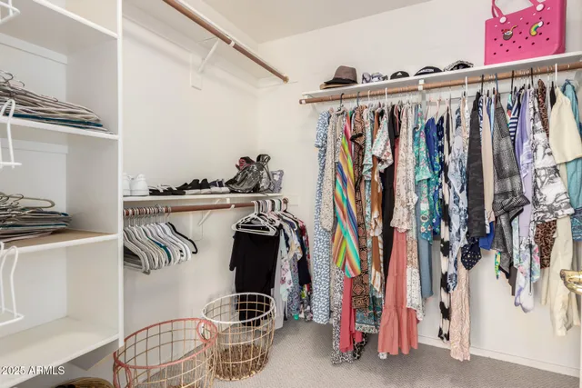 a view of walk in closet with clothes