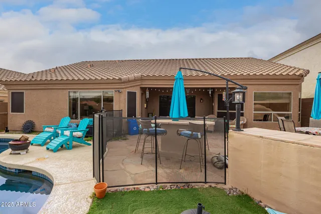 a patio with a table and chairs and potted plants