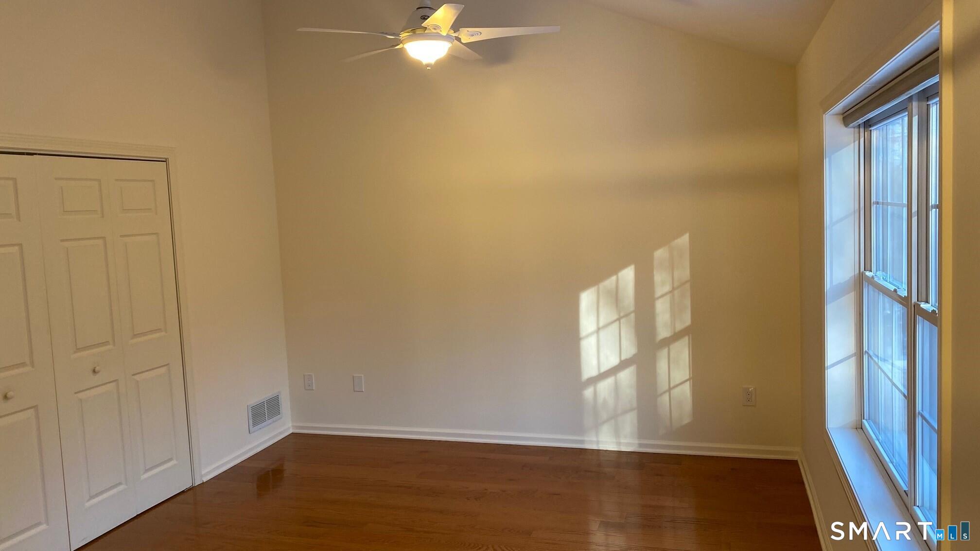 403 Larson Drive, Unit 403 Danbury, CT 06810 - Photo 14 of 34 a view of an empty room with wooden floor and a window