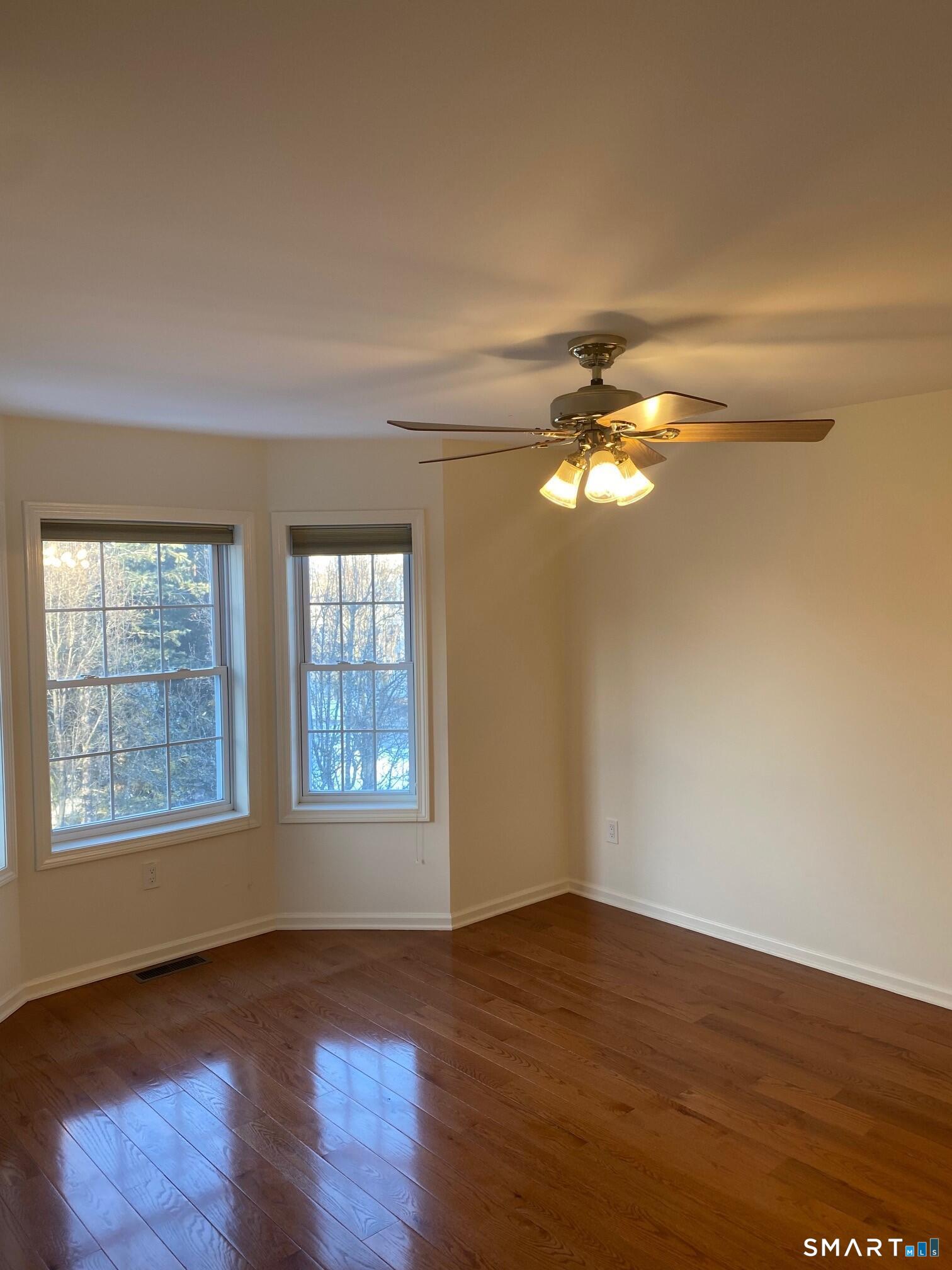 403 Larson Drive, Unit 403 Danbury, CT 06810 - Photo 18 of 34 a view of an empty room with wooden floor and a window