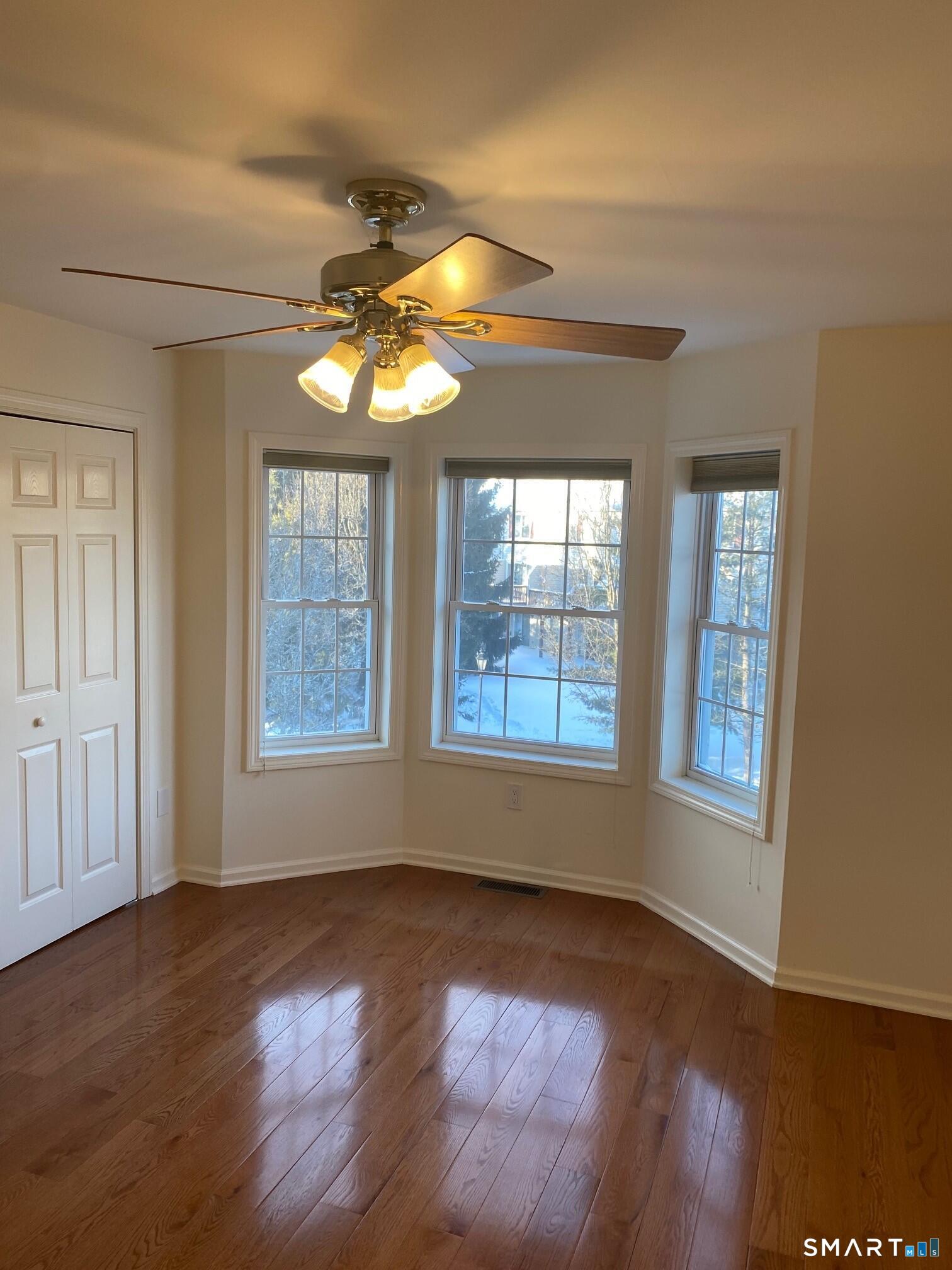 403 Larson Drive, Unit 403 Danbury, CT 06810 - Photo 19 of 34 a view of an empty room with wooden floor and a window