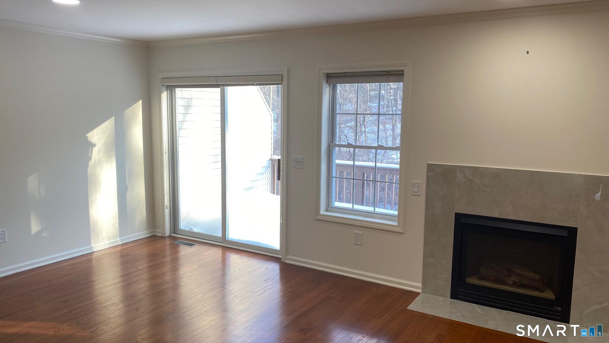 403 Larson Drive, Unit 403 Danbury, CT 06810 - Photo 3 of 34 an empty room with windows and fireplace