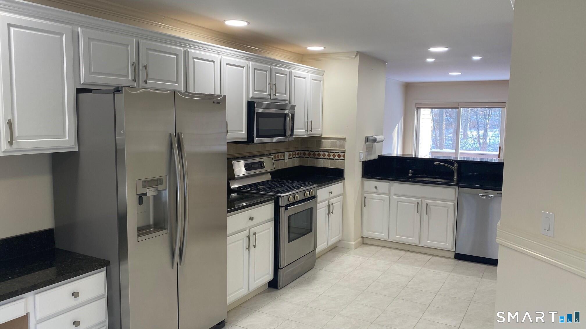 403 Larson Drive, Unit 403 Danbury, CT 06810 - Photo 5 of 34 a kitchen with stainless steel appliances a refrigerator sink and cabinets