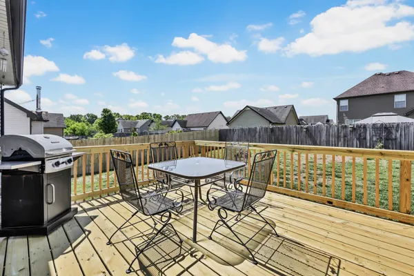 a view of a back yard with an tree and wooden fence