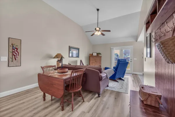 a view of a livingroom with furniture a chandelier and wooden floor