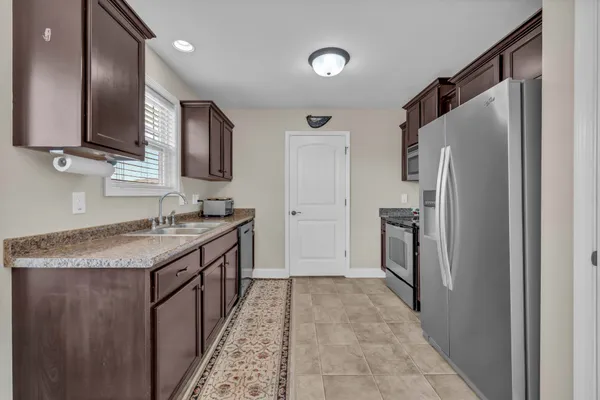 a kitchen with granite countertop a refrigerator and a sink