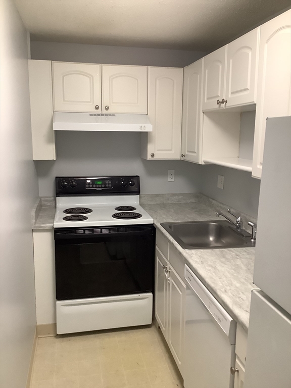 a kitchen with granite countertop white cabinets and stainless steel appliances