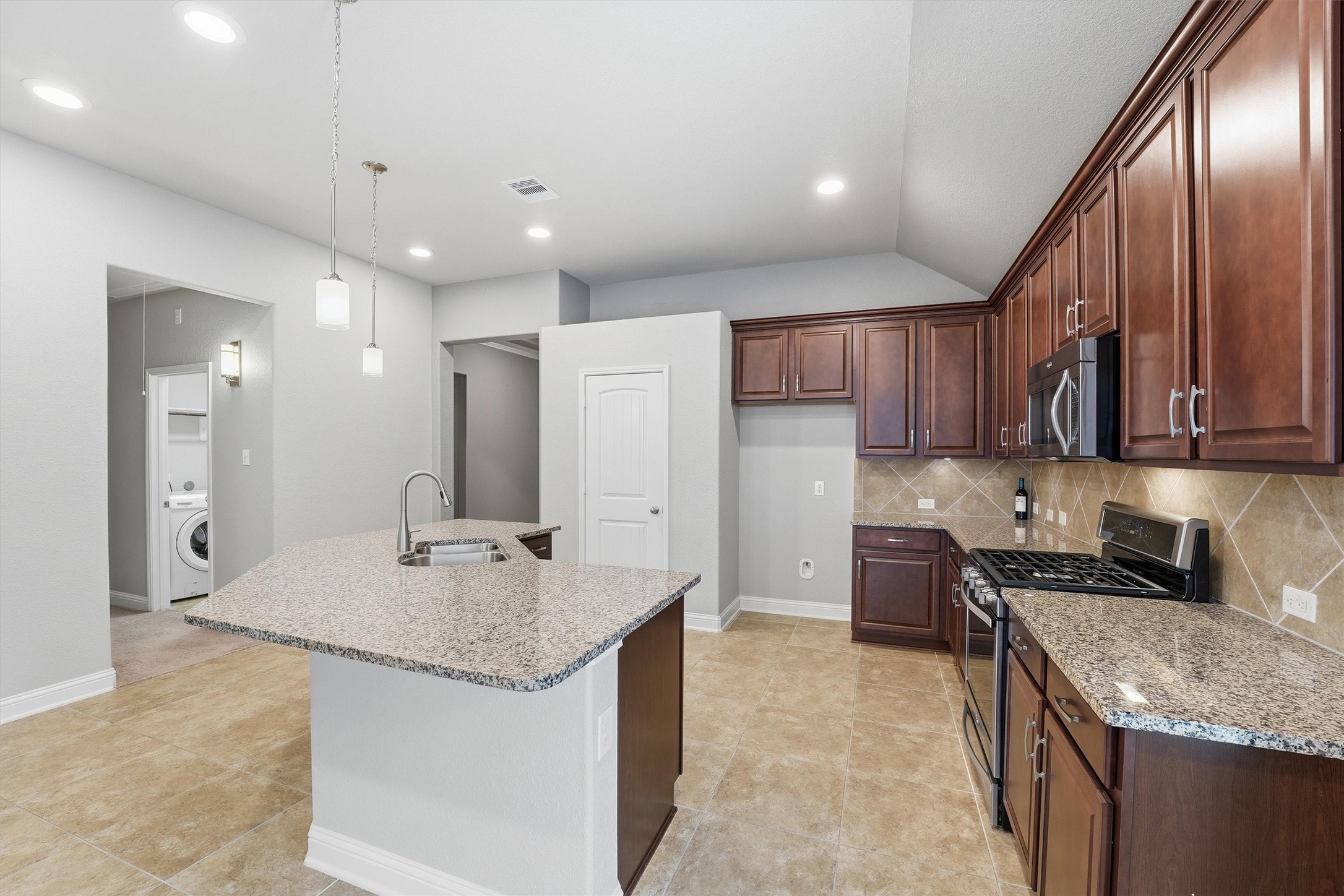 1911 Cedar Ridge Lane Pearland, TX 77089 - Photo 8 of 33 Island kitchen with granite counters, tile backsplash, 42 inch cabinets, and stainless steel appliances.
