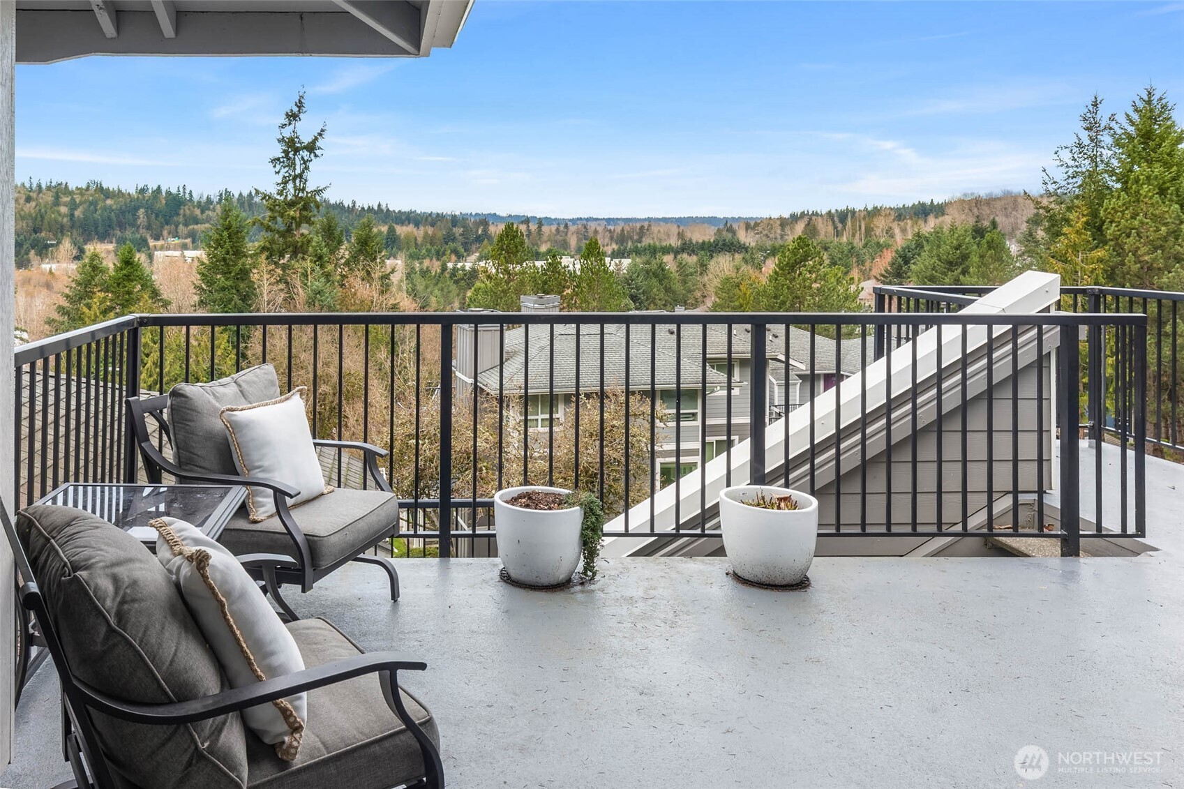 12023 Northeast 204th Place, Unit E302 Bothell, WA 98011 - Photo 1 of 26 a balcony with furniture and a potted plant