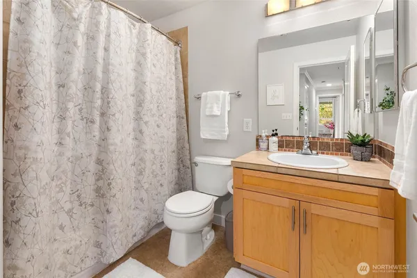 a bathroom with a sink a toilet and a mirror