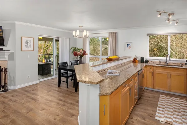 a very nice looking dining room with kitchen island granite countertop a sink and a refrigerator