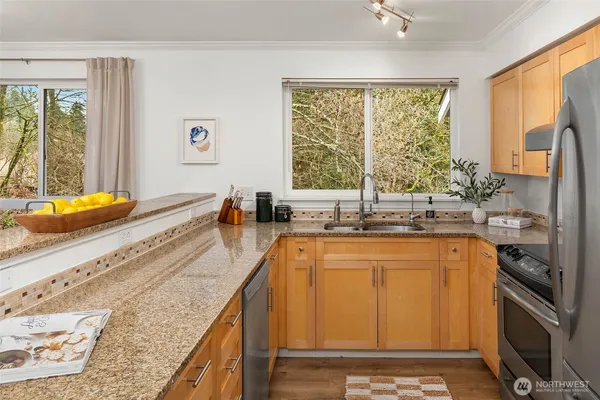 a kitchen with stainless steel appliances granite countertop a sink stove and refrigerator