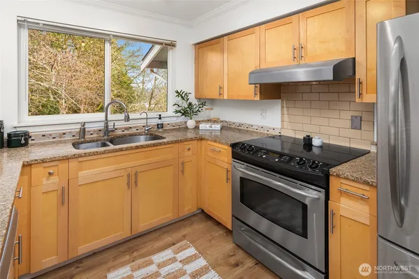 a kitchen with stainless steel appliances a stove sink and cabinets