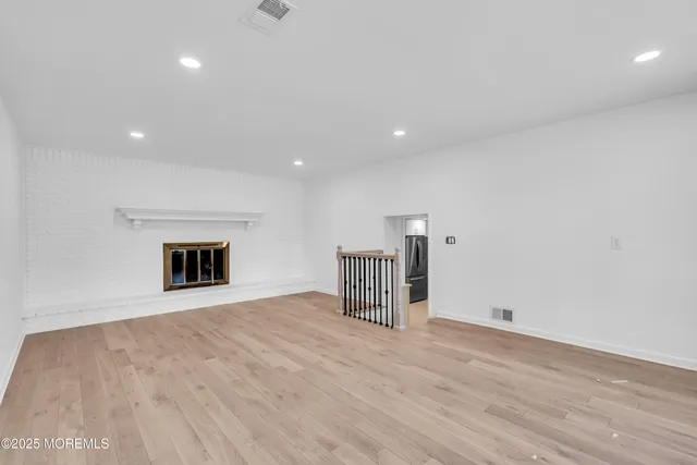 an empty room with wooden floor and fireplace
