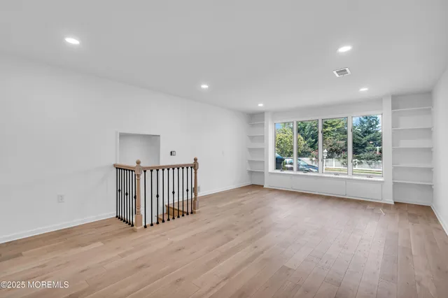a view of a room with wooden floor and windows