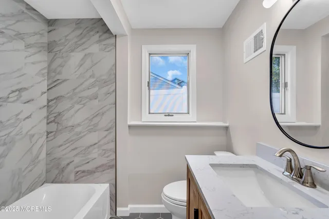 a bathroom with a sink a toilet and a mirror