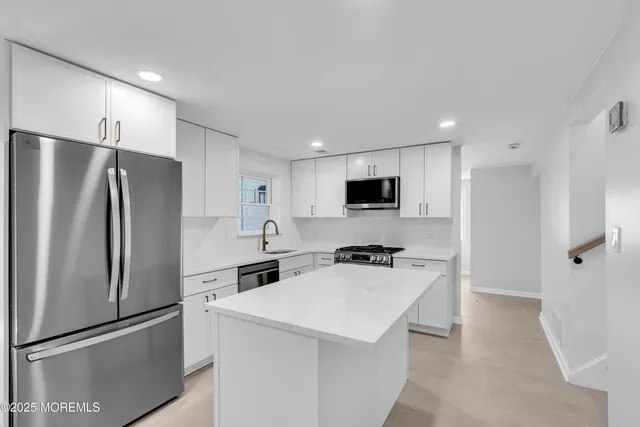 a kitchen with stainless steel appliances a refrigerator stove microwave and sink