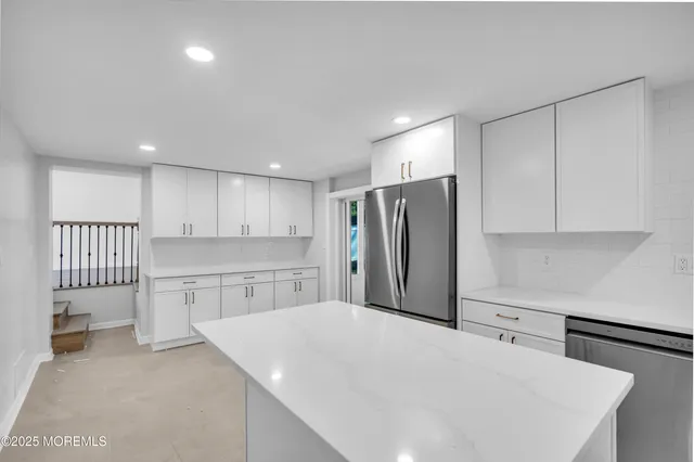 a kitchen with a refrigerator a sink and cabinets