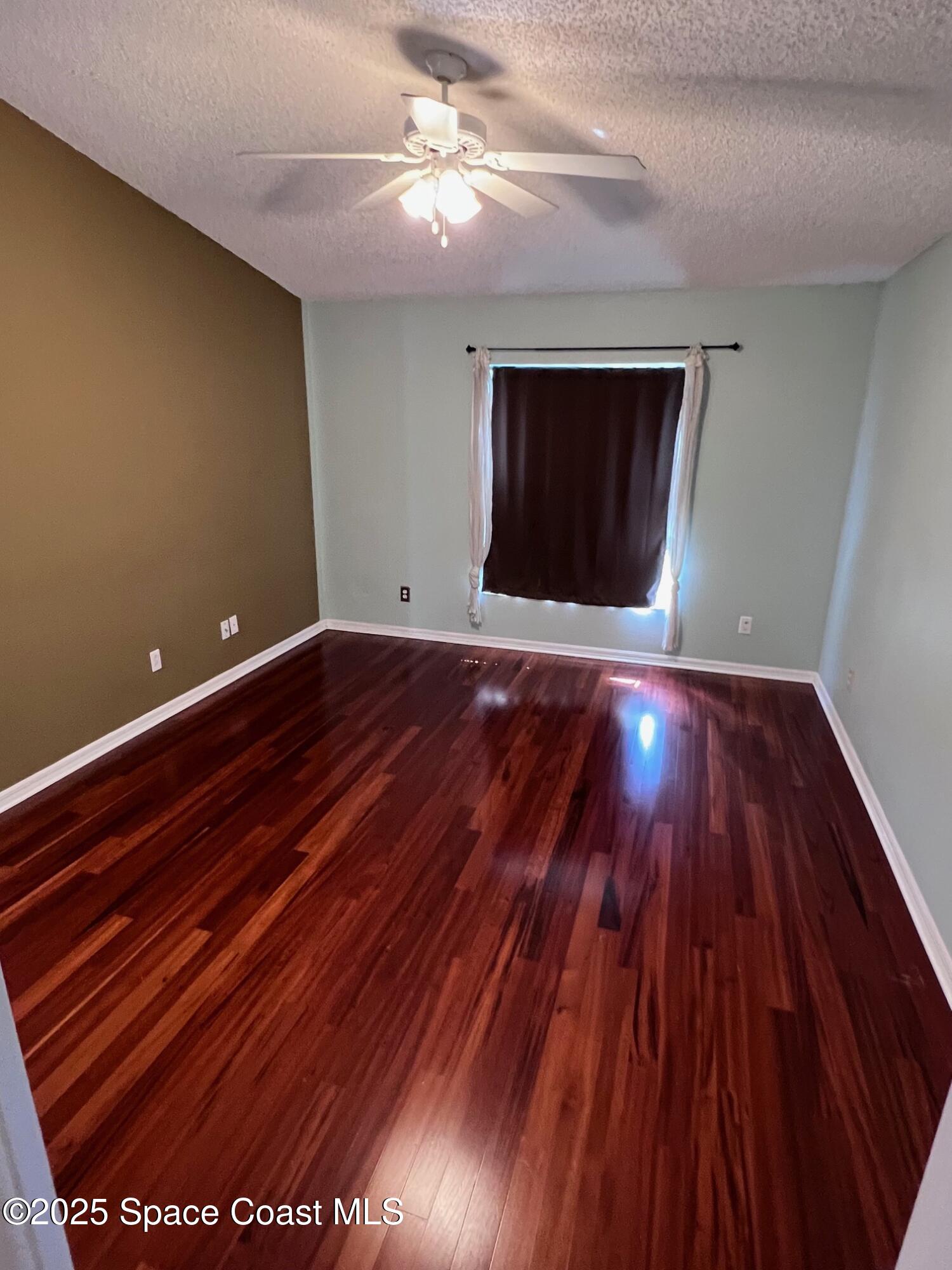 2149 Caledonia Place Melbourne, FL 32940 - Photo 11 of 18 a view of room with wooden floor and ceiling fan