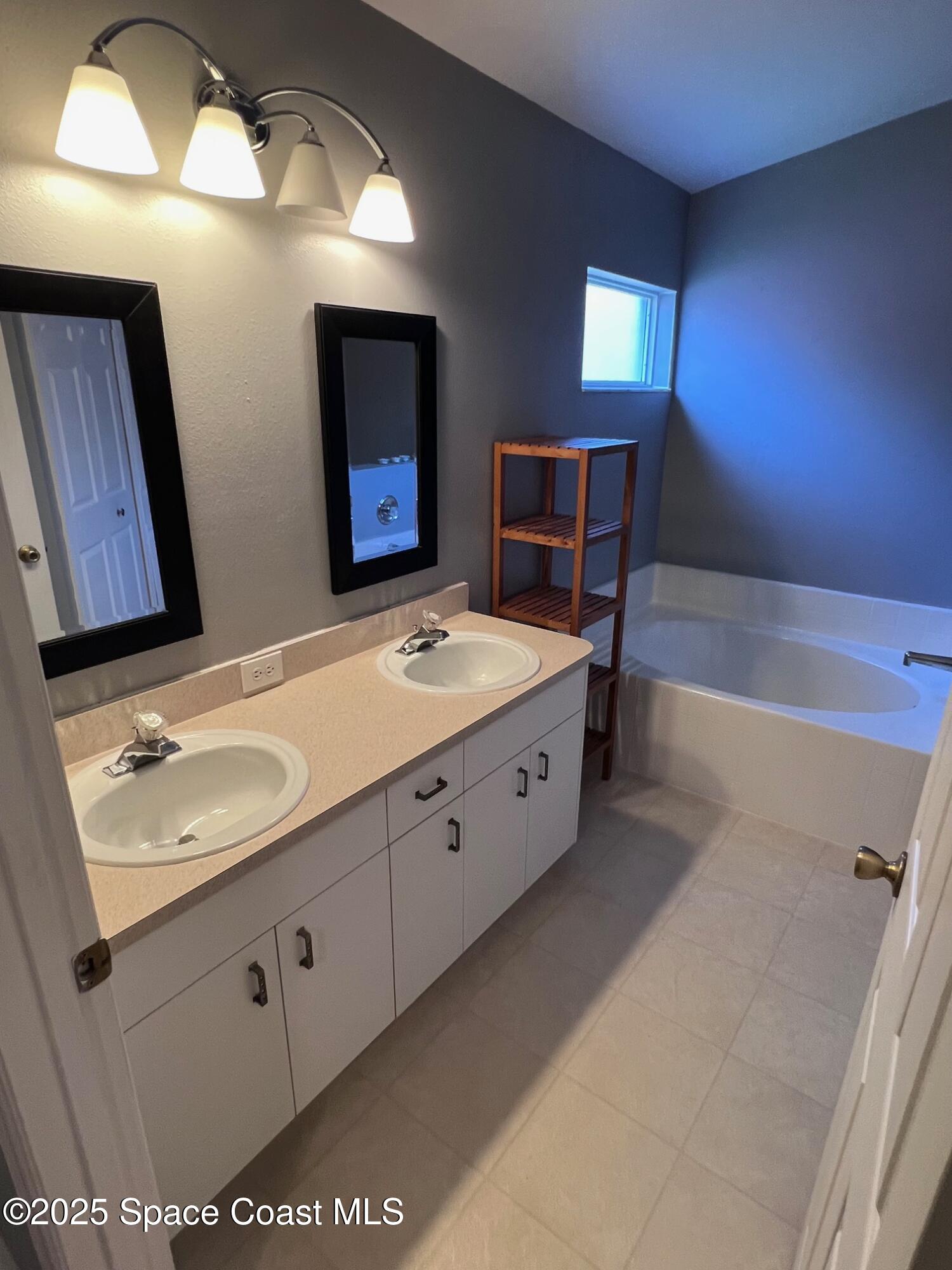 2149 Caledonia Place Melbourne, FL 32940 - Photo 15 of 18 a bathroom with a double vanity sink and a mirror