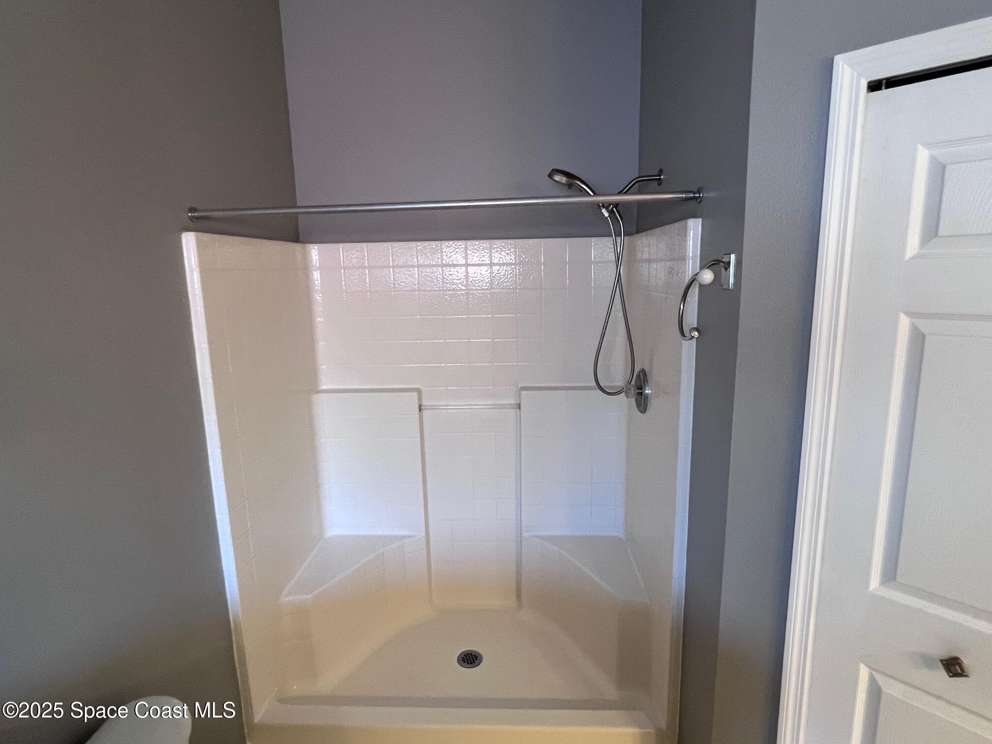 2149 Caledonia Place Melbourne, FL 32940 - Photo 17 of 18 a bathroom with a glass shower door