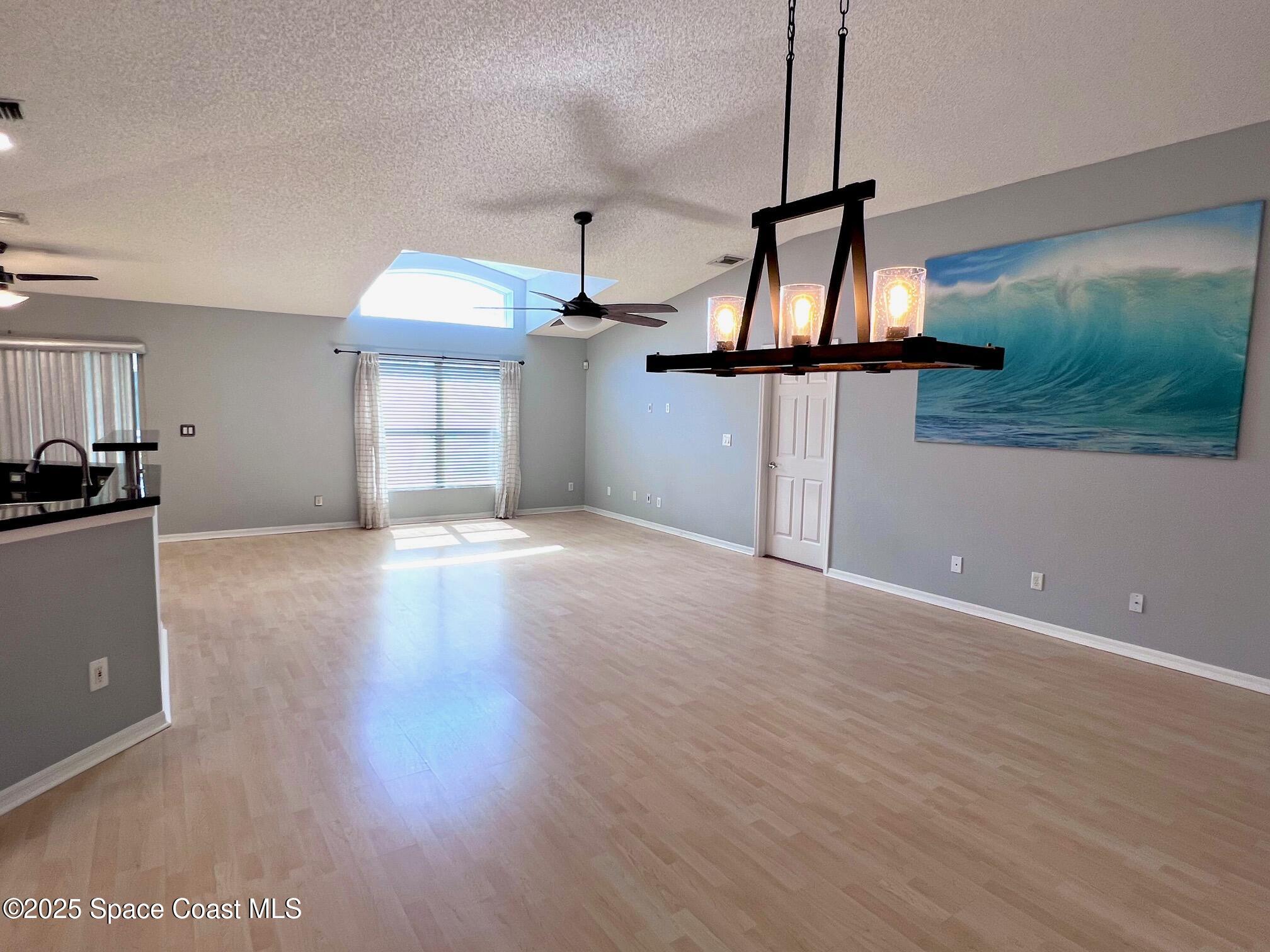 2149 Caledonia Place Melbourne, FL 32940 - Photo 8 of 18 a view of wooden floor and a chandelier in a room