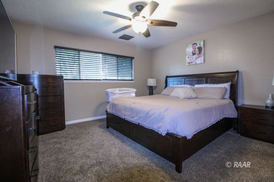 221 South Primrose Street Ridgecrest, CA 93555 - Photo 22 of 29 a bedroom with a bed and a chandelier