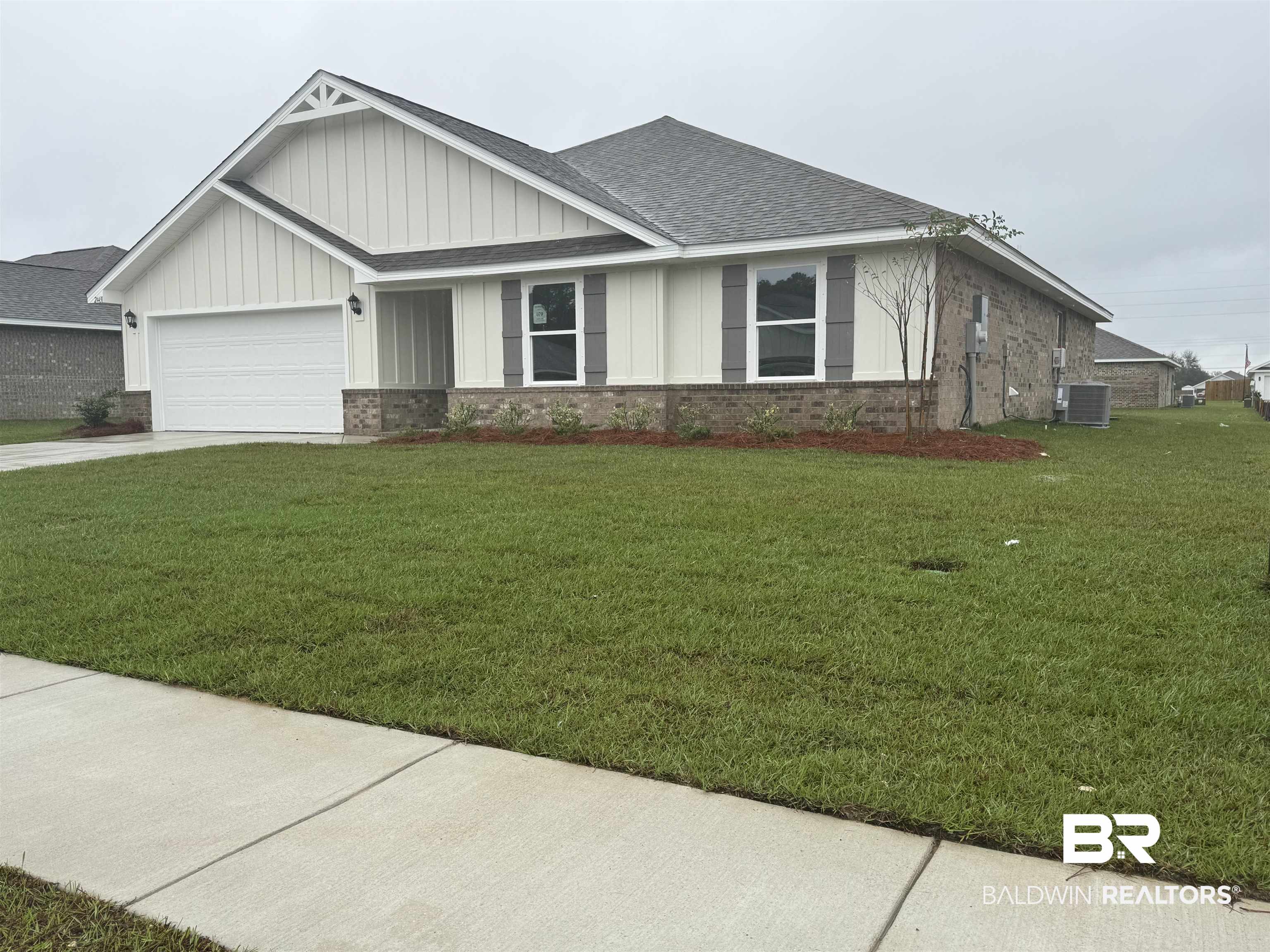 24431 Ringneck Loop Elberta, AL 36530 - Photo 3 of 15 View of front of property featuring central air condition unit, a garage, and a front yard