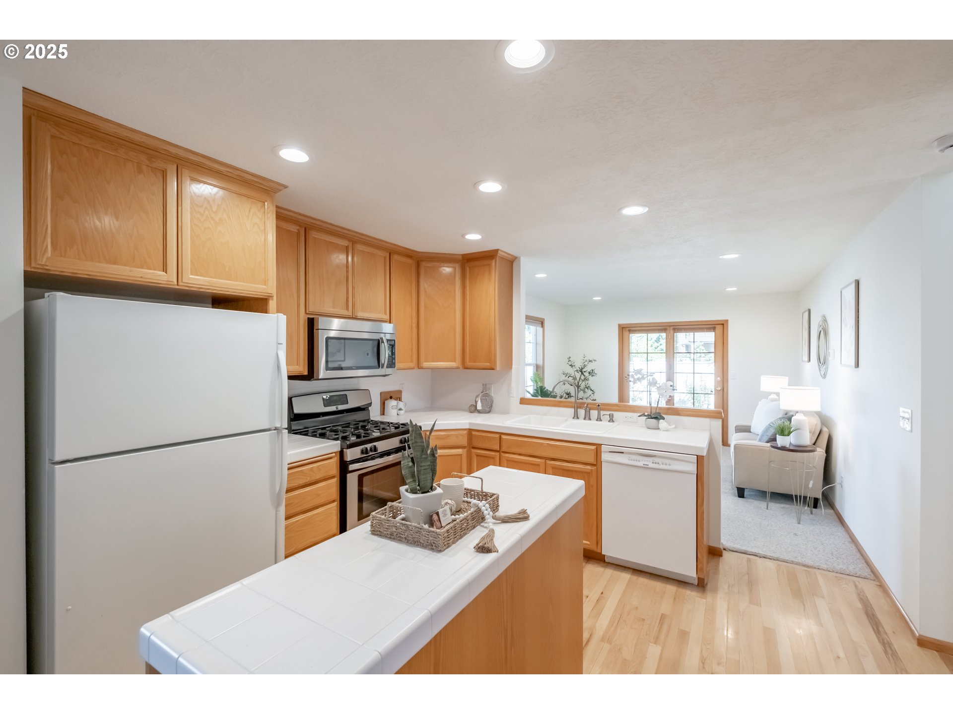 2009 Chase Loop Southwest Albany, OR 97321 - Photo 15 of 48 a kitchen with a refrigerator a stove top oven a sink dishwasher and white cabinets with wooden floor