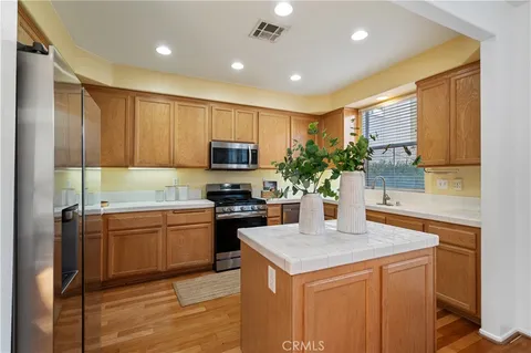 a kitchen with kitchen island granite countertop a sink stove and refrigerator