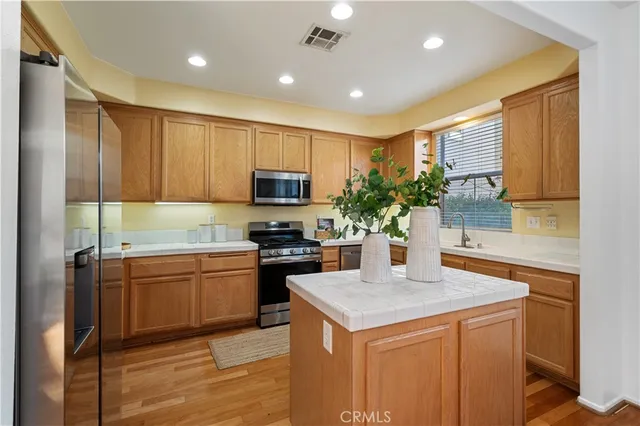 a kitchen with kitchen island granite countertop a sink stove and refrigerator