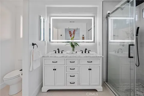 a bathroom with a granite countertop sink vanity mirror and shower