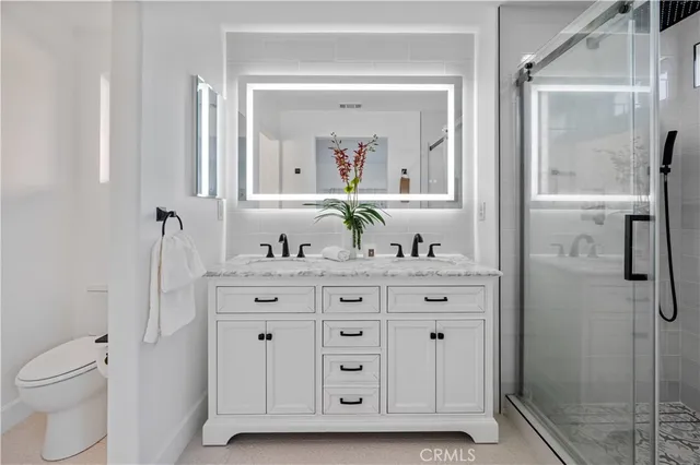 a bathroom with a granite countertop sink vanity mirror and shower
