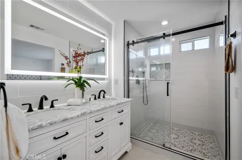 a bathroom with a granite countertop shower sink and mirror