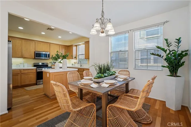 a dining room with furniture a chandelier and kitchen view