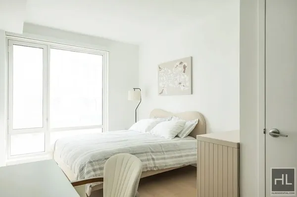 a bedroom with a bed and a window