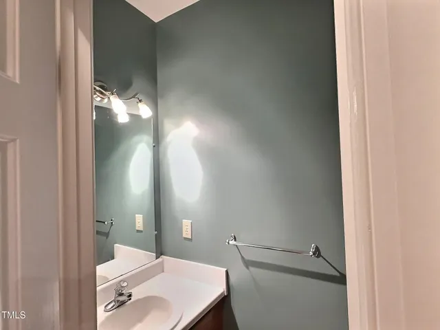 a bathroom with a sink and mirror with toilet