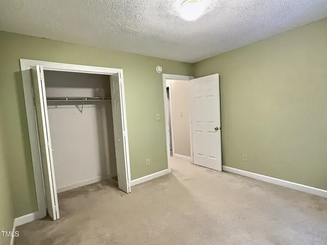 an empty room with closet and a bathroom
