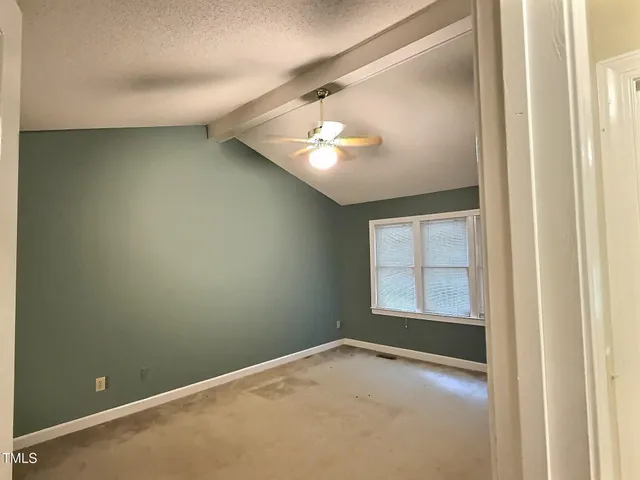 an empty room with a window and fireplace