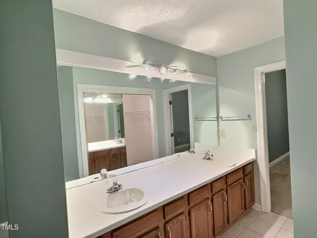 a bathroom with a sink vanity granite tub and a mirror