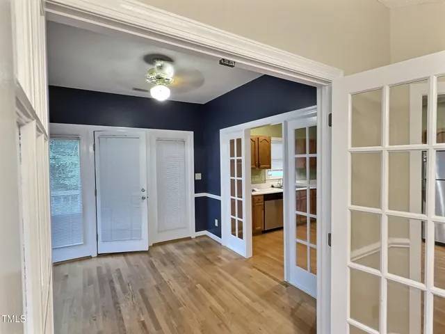 a view of a hallway with wooden floor and windows