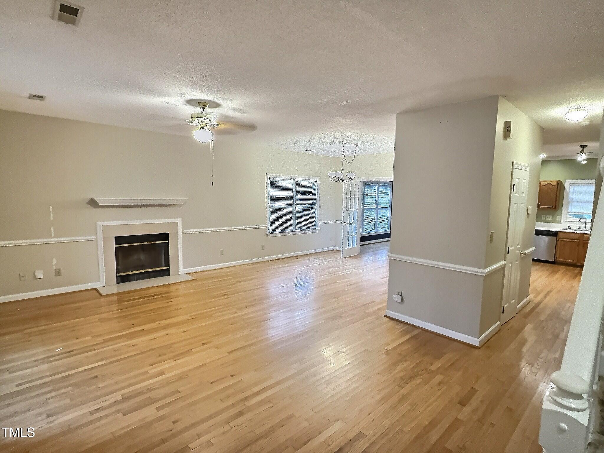 7 Preakness Drive Durham, NC 27713 - Photo 7 of 32 a view of a livingroom with wooden floor and a kitchen space