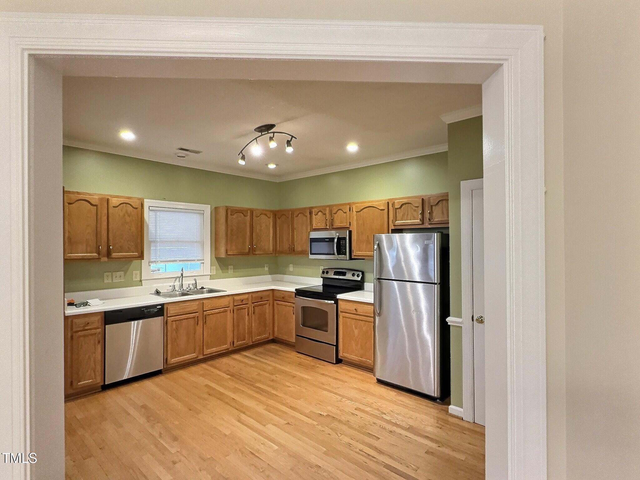 7 Preakness Drive Durham, NC 27713 - Photo 9 of 32 a kitchen with stainless steel appliances granite countertop a refrigerator a sink dishwasher a stove with wooden cabinets